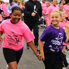 A celebration guest dances and claps for Girls on the Run